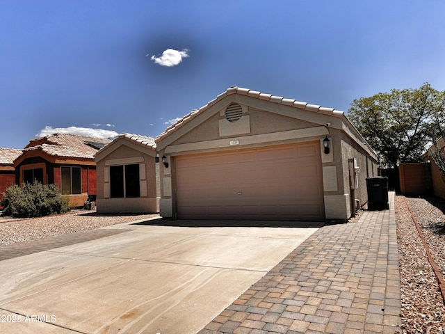 ranch-style house featuring stucco siding, concrete driveway, a garage, and a tiled roof
