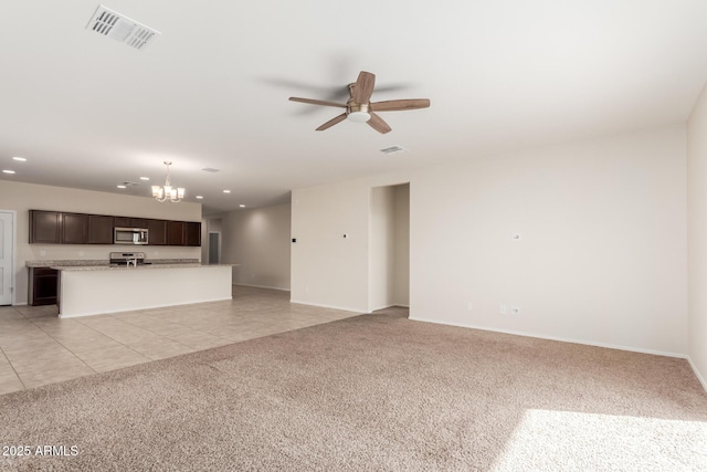 unfurnished living room with light tile patterned flooring and ceiling fan with notable chandelier