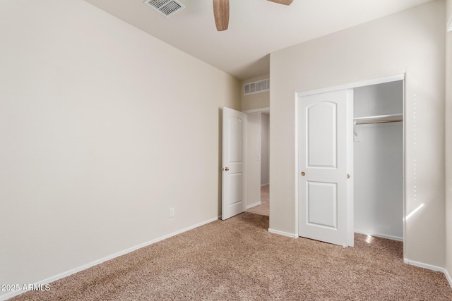 unfurnished bedroom featuring ceiling fan, a closet, and light colored carpet