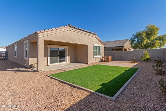 rear view of house with a lawn and a patio