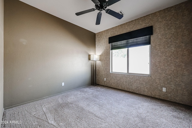 spare room featuring ceiling fan and carpet floors