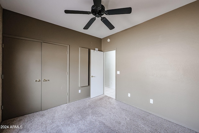 unfurnished bedroom with light carpet, a closet, and ceiling fan