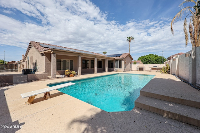 view of pool featuring a diving board and a patio