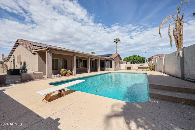 view of swimming pool with a diving board and a patio area