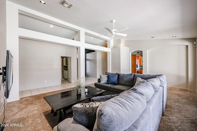 living room with ceiling fan, light tile patterned floors, and vaulted ceiling