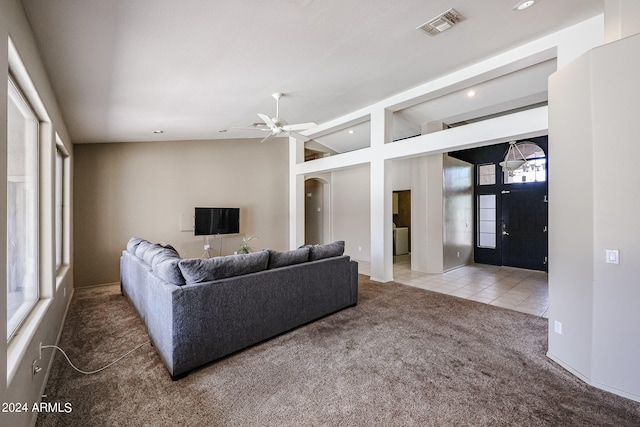 living room featuring light carpet, vaulted ceiling, ceiling fan, and a healthy amount of sunlight