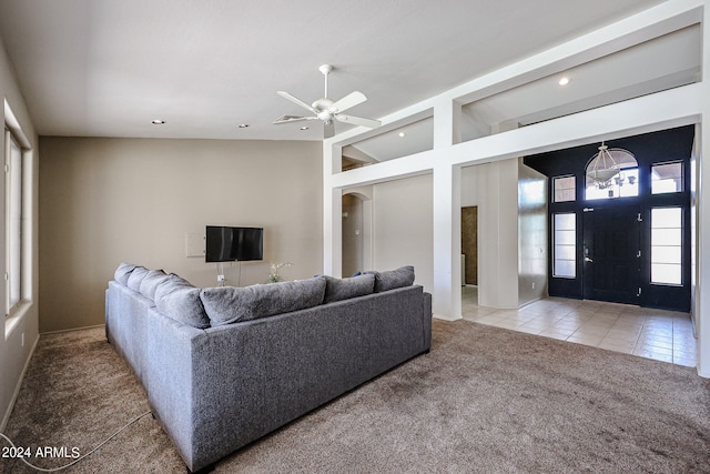 living room featuring ceiling fan, vaulted ceiling, and light tile patterned floors