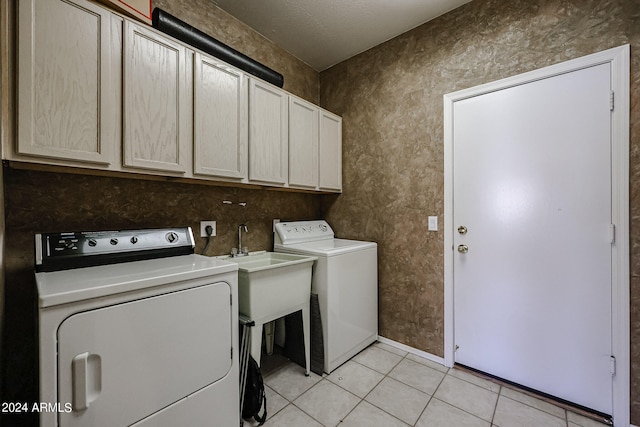 laundry area with light tile patterned flooring, independent washer and dryer, and cabinets