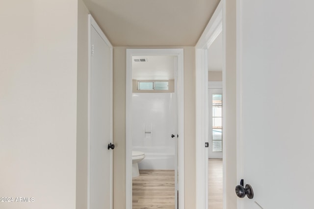 hall with visible vents and wood finished floors