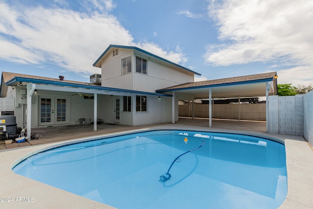 view of swimming pool featuring a fenced in pool, french doors, a patio area, and fence