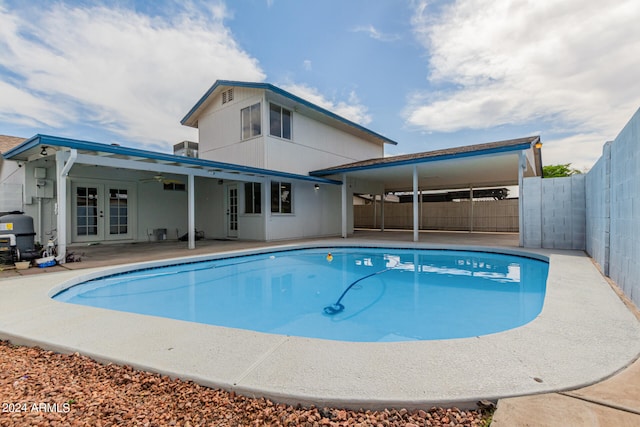 view of pool featuring ceiling fan, a fenced backyard, french doors, a fenced in pool, and a patio area