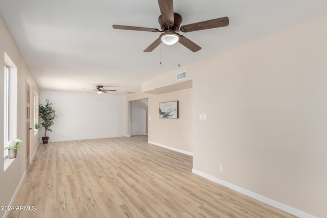 spare room featuring light wood-style floors, baseboards, and visible vents