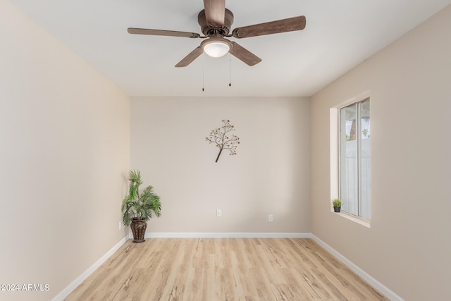 spare room featuring ceiling fan, light wood-style floors, and baseboards