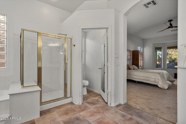 bathroom featuring ceiling fan, toilet, and a shower with door