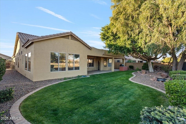 rear view of house with a yard and a patio