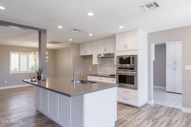 kitchen featuring white cabinets, appliances with stainless steel finishes, light hardwood / wood-style floors, and sink