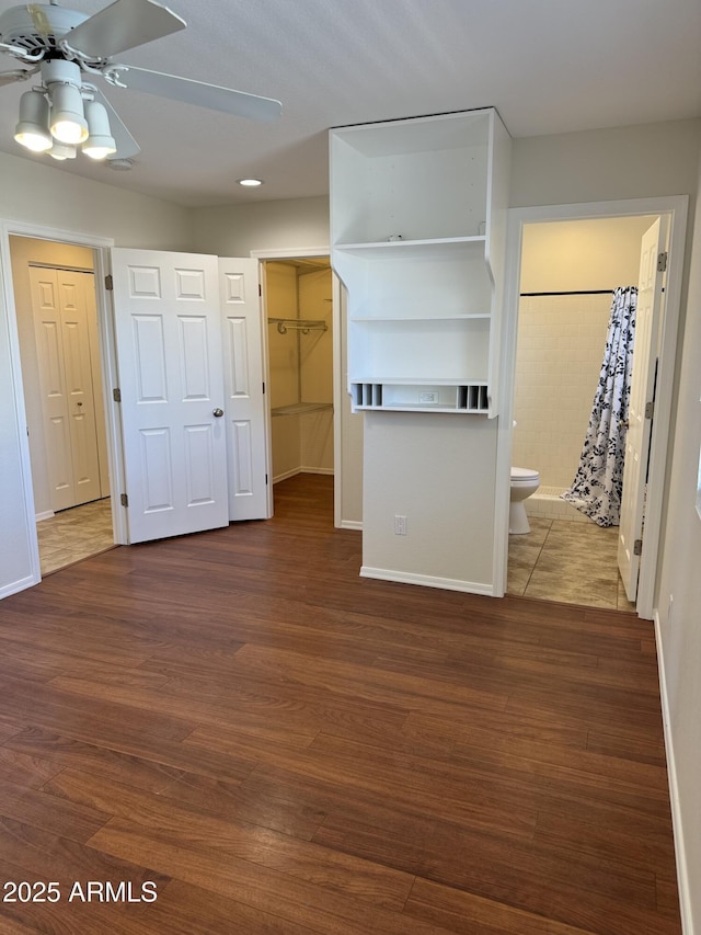 unfurnished living room with ceiling fan and dark hardwood / wood-style flooring