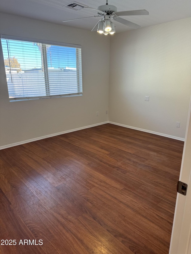 empty room featuring dark hardwood / wood-style flooring and ceiling fan