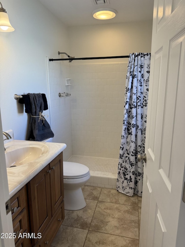 bathroom with a shower with curtain, vanity, toilet, and tile patterned flooring