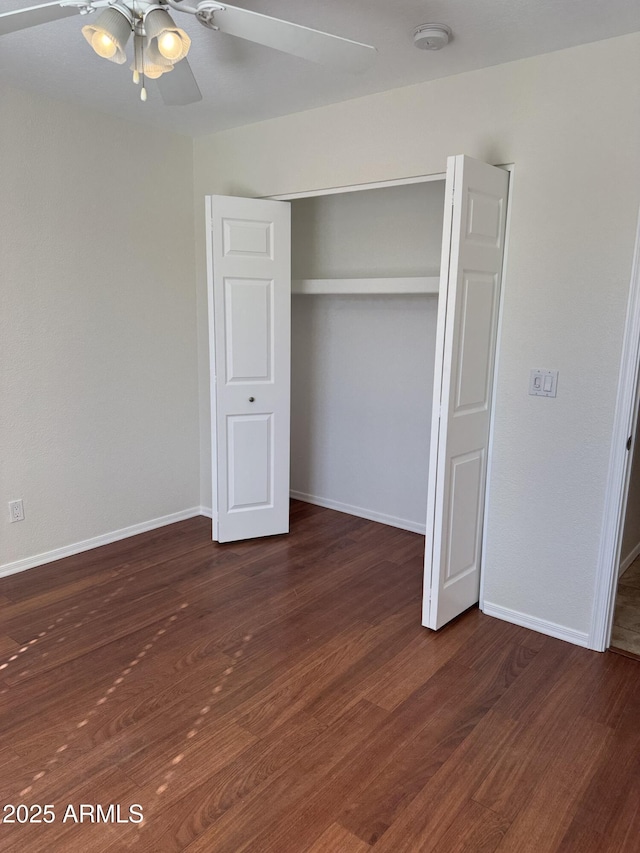 unfurnished bedroom with ceiling fan, dark hardwood / wood-style flooring, and a closet