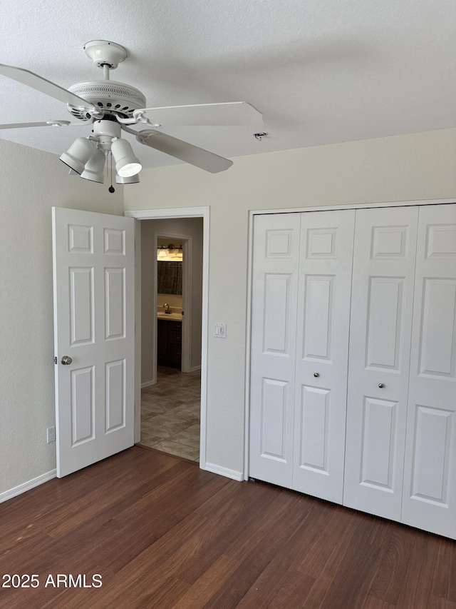 unfurnished bedroom featuring a closet, dark hardwood / wood-style floors, and ceiling fan