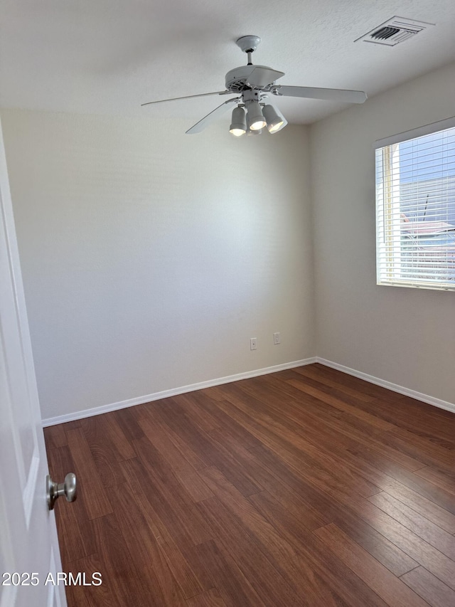 spare room with dark hardwood / wood-style floors and ceiling fan