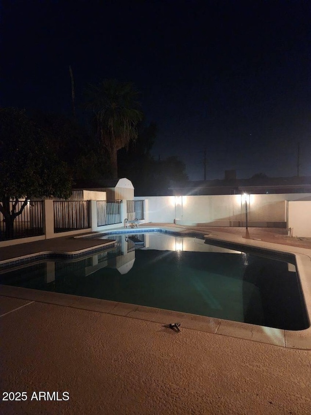 pool at twilight with a patio area