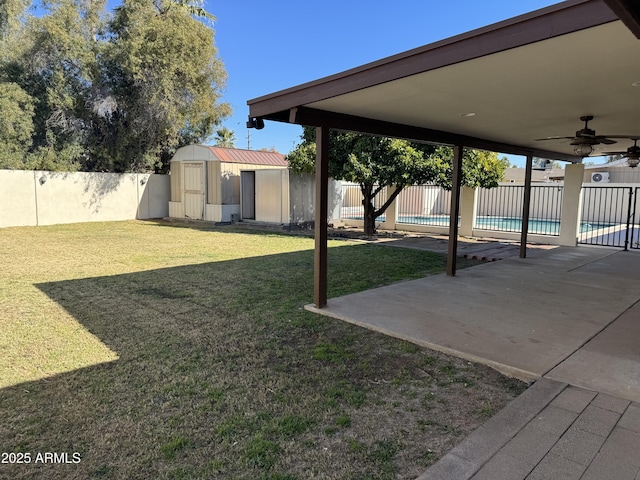 view of yard with a shed, a fenced in pool, a patio area, and ceiling fan