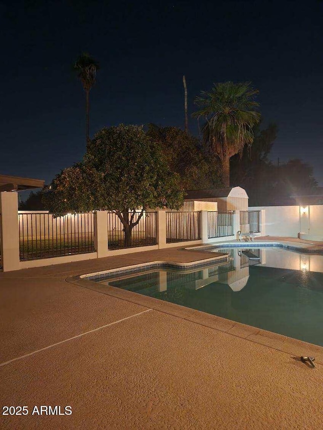 pool at night with a patio area