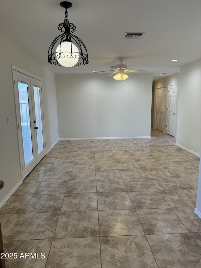 tiled empty room with ceiling fan and french doors