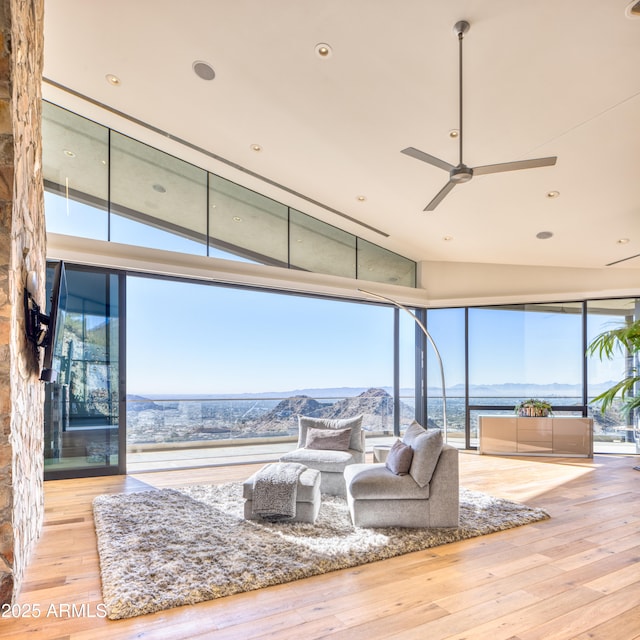 living room with a wealth of natural light, hardwood / wood-style floors, floor to ceiling windows, and ceiling fan