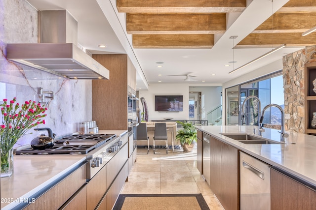 kitchen featuring a sink, light countertops, appliances with stainless steel finishes, modern cabinets, and island range hood