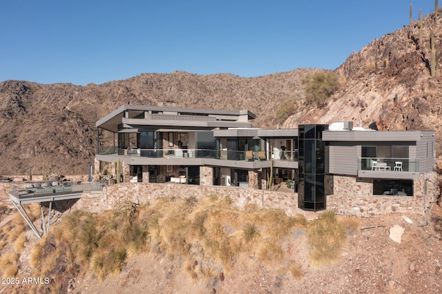 rear view of property featuring a mountain view and stone siding