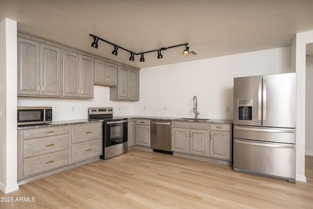 12424 N B St, El Mirage, AZ 85335 - kitchen featuring appliances with stainless steel finishes, a sink, light wood-type flooring, track lighting, and light stone counters