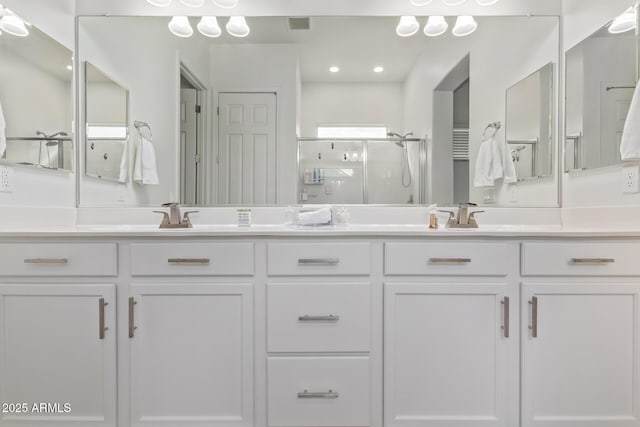 bathroom with vanity and a shower with shower door