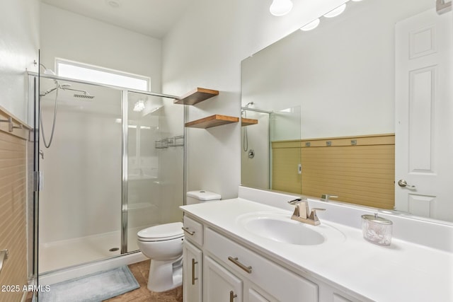 bathroom featuring vanity, tile patterned flooring, a shower with shower door, and toilet