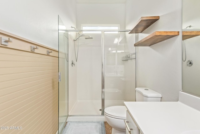 bathroom with toilet, vanity, and a shower with shower door