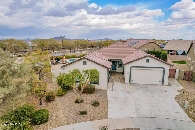 view of front facade with a garage, a gazebo, and a mountain view