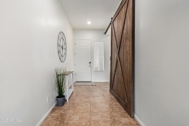 corridor with a barn door and light tile patterned floors