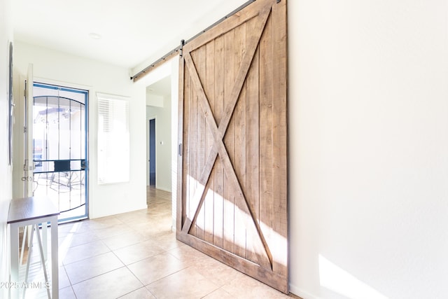 tiled foyer featuring a barn door