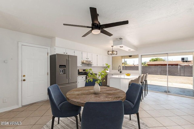 dining space with a textured ceiling, ceiling fan, light tile patterned flooring, and sink