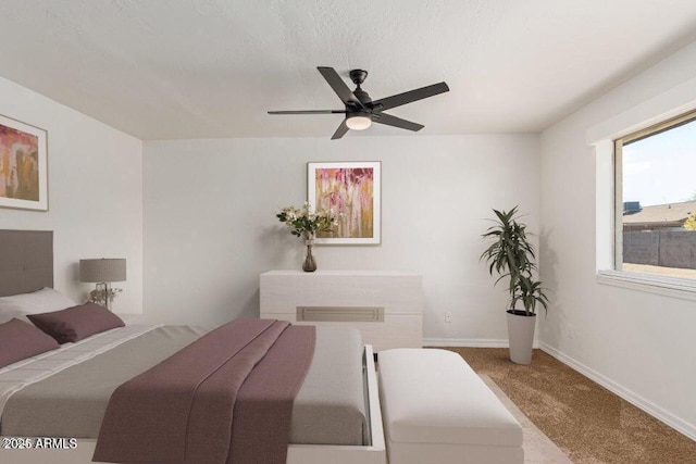 carpeted bedroom featuring ceiling fan and a textured ceiling