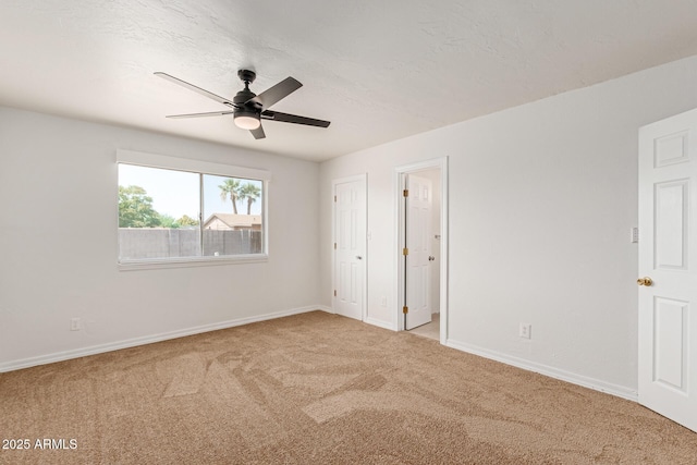 unfurnished bedroom with ceiling fan and light colored carpet