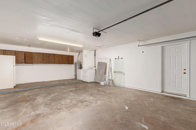 garage featuring white fridge, gas water heater, separate washer and dryer, and a garage door opener