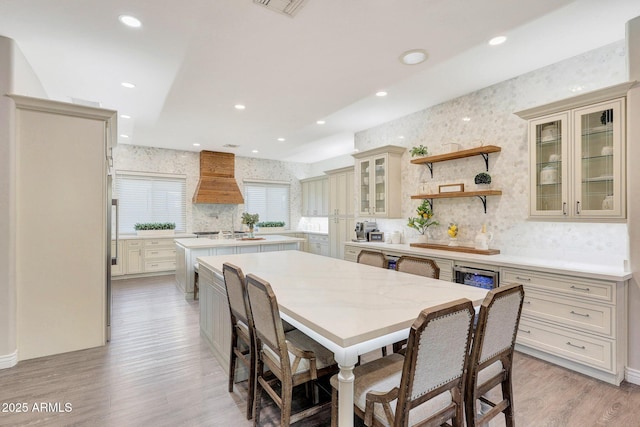 kitchen featuring custom range hood, cream cabinets, and a kitchen island