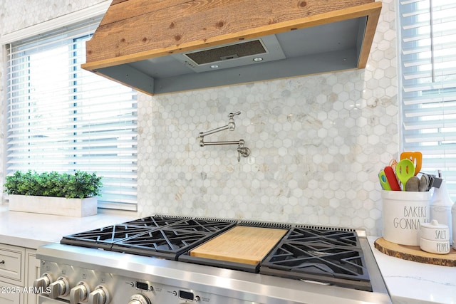 kitchen with backsplash, a wealth of natural light, and stainless steel range with gas cooktop