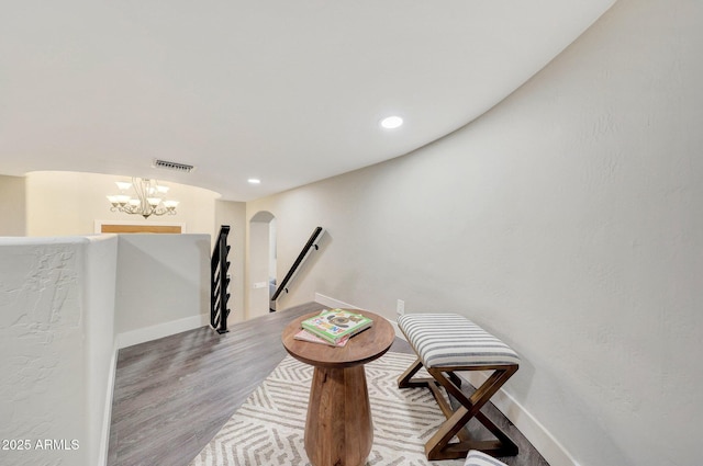 sitting room featuring an inviting chandelier and hardwood / wood-style floors