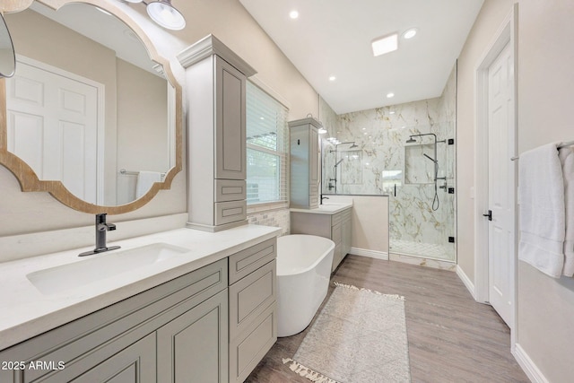 bathroom with vanity, wood-type flooring, and plus walk in shower