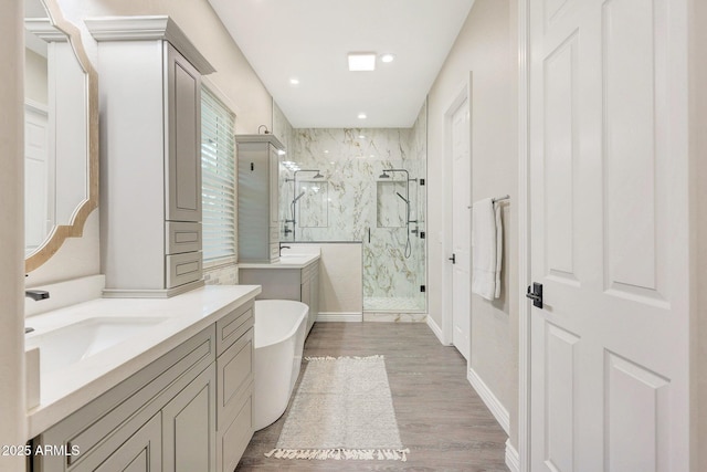 bathroom featuring hardwood / wood-style flooring, vanity, and separate shower and tub