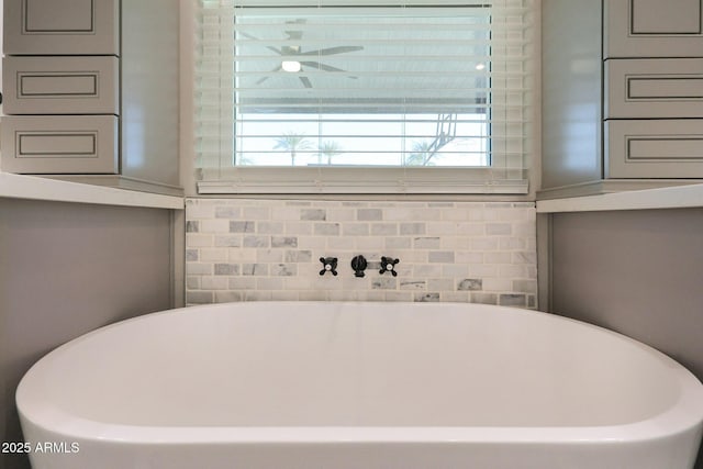 details featuring ceiling fan and a tub to relax in